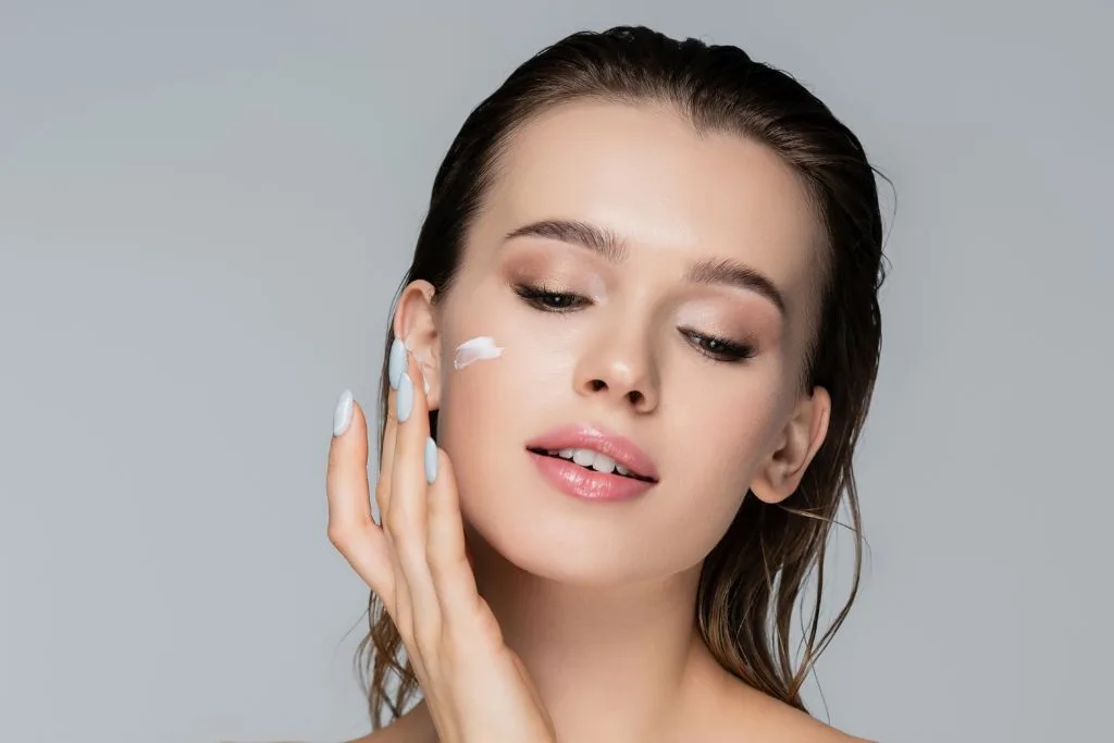 Woman putting on face cream.